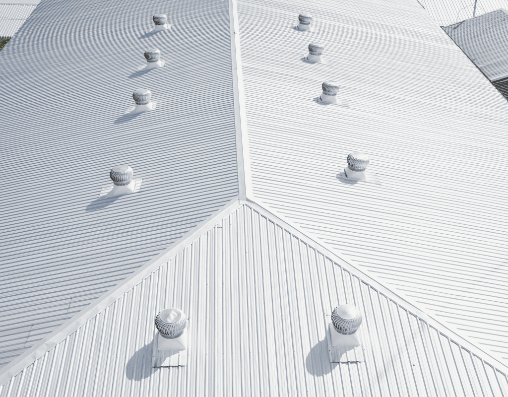 White standing seam metal commercial roof with ventilation units installed