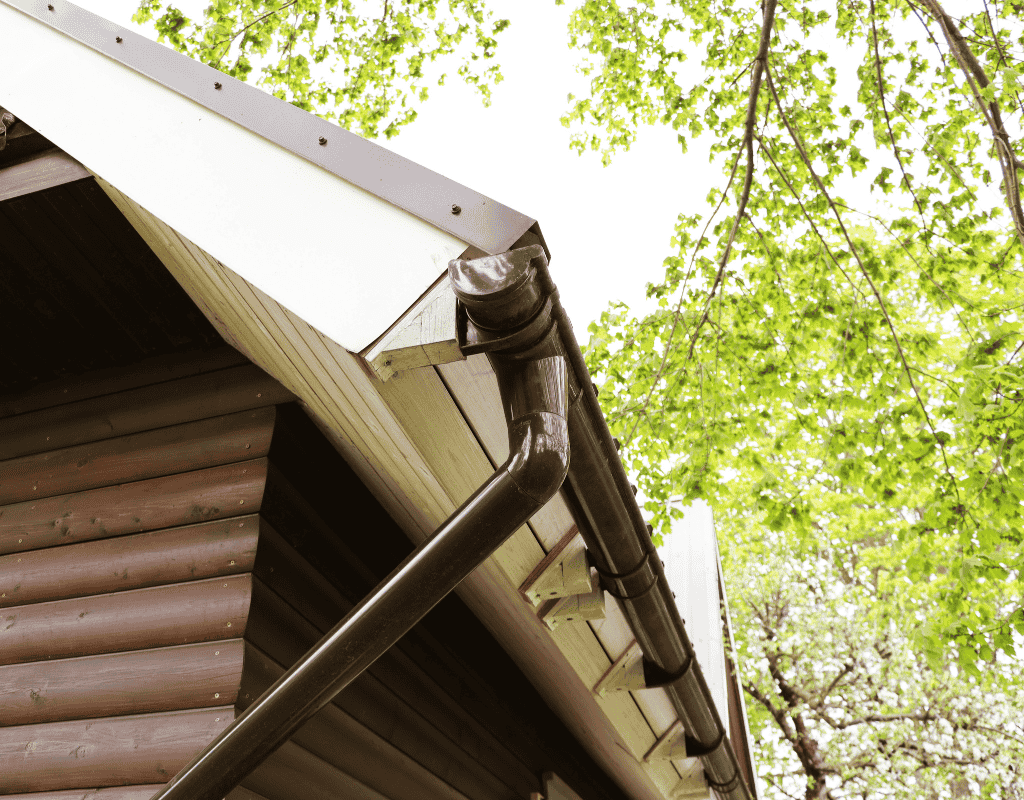 Brown aluminum gutter and downspout installed along residential roof edge in Chicagoland home