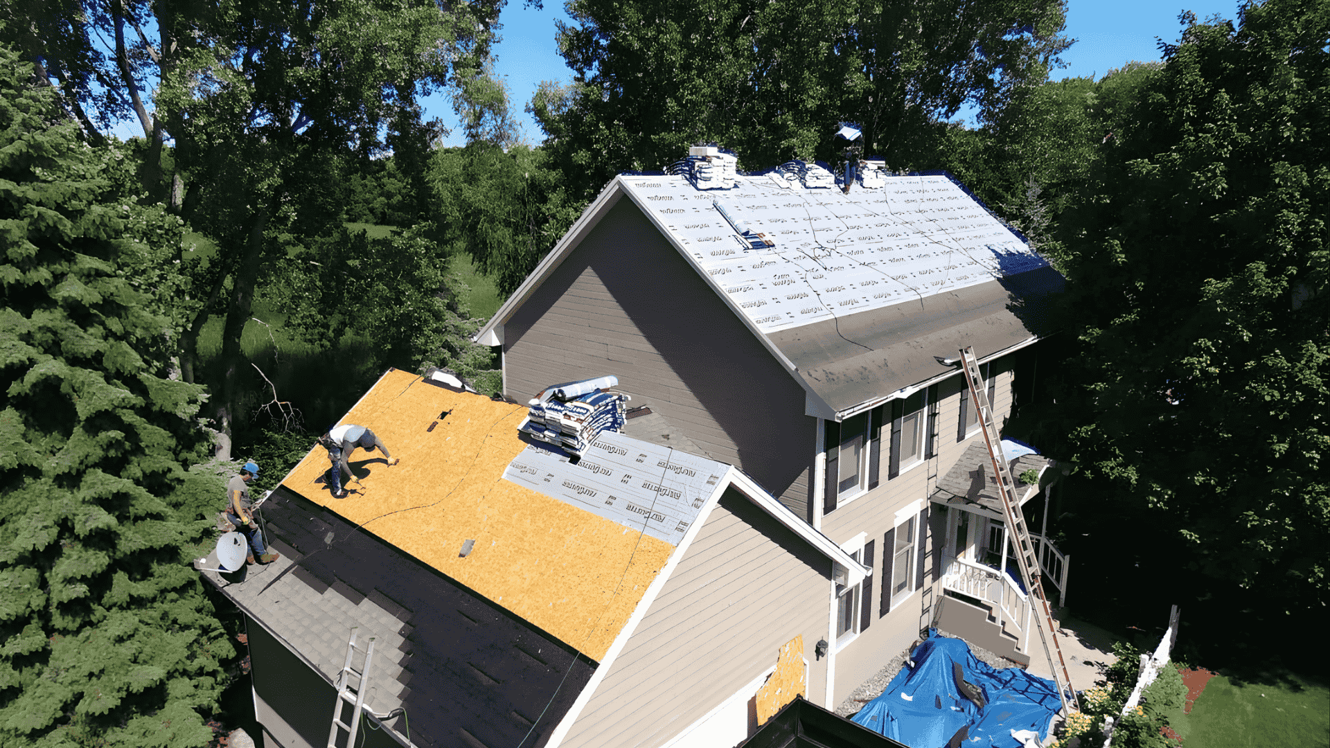 Roofing contractors performing full roof replacement on large residential home in Chicagoland Illinois