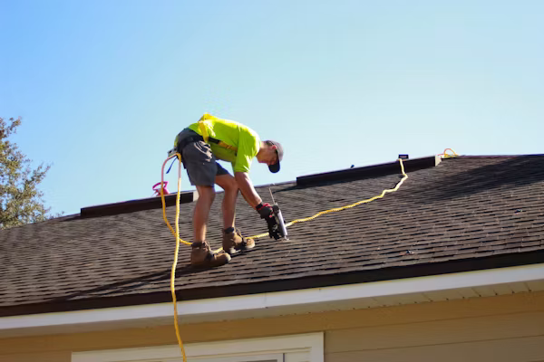 Roofing professional inspecting flashing, ventilation, and decking before completing complex installation