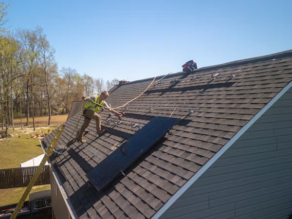 Roofing specialist documenting ventilation and flashing issues during detailed rooftop inspection