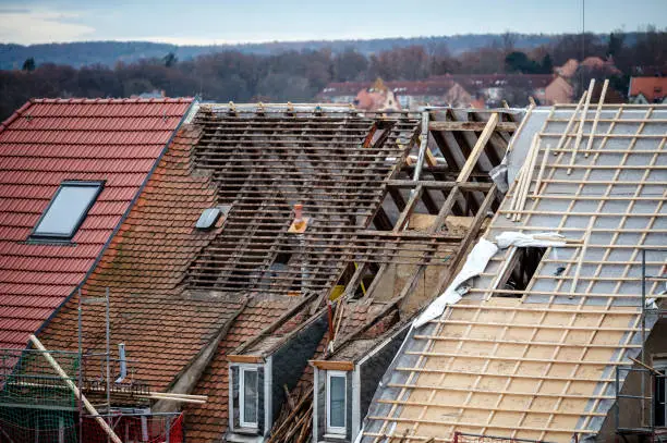 Roofer repairing flashing and shingles on Evanston home after recurring leak
