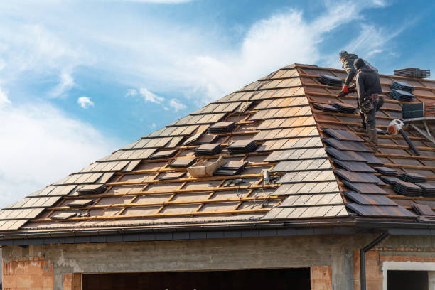 Roof Repair in Highland Park - IL underway as a roofer replaces damaged shingles near a chimney